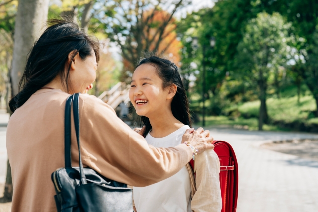 ランドセル姿の小学生と母親