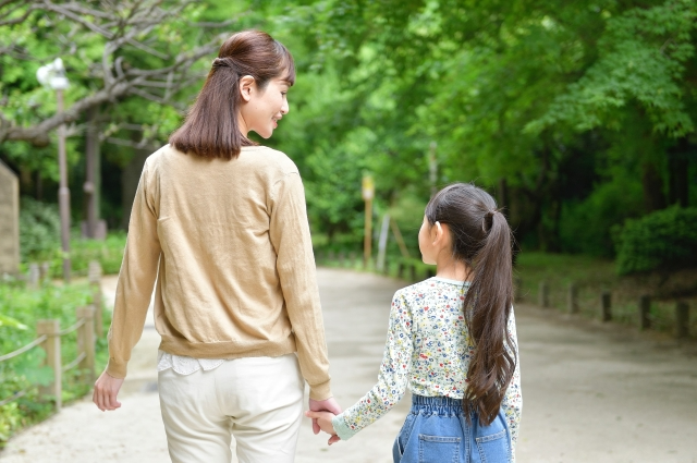 手を繋いで仲睦まじく歩く親子