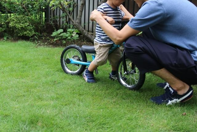 自転車の練習をしている親子