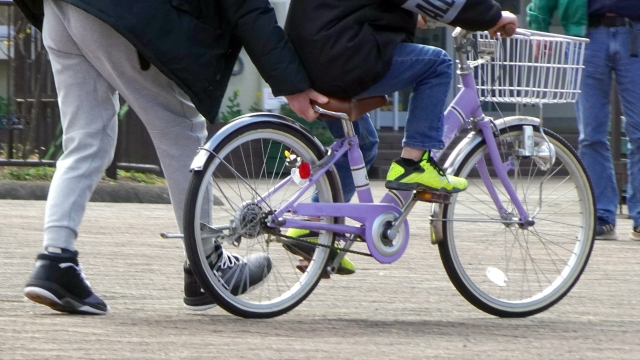 自転車の練習をする親子